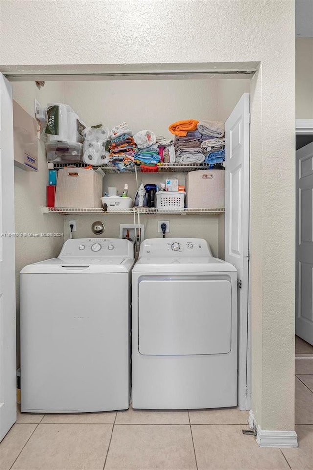 laundry room with laundry area, tile patterned flooring, and washer and clothes dryer