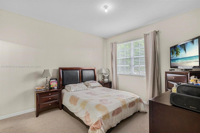 bedroom with light carpet and baseboards