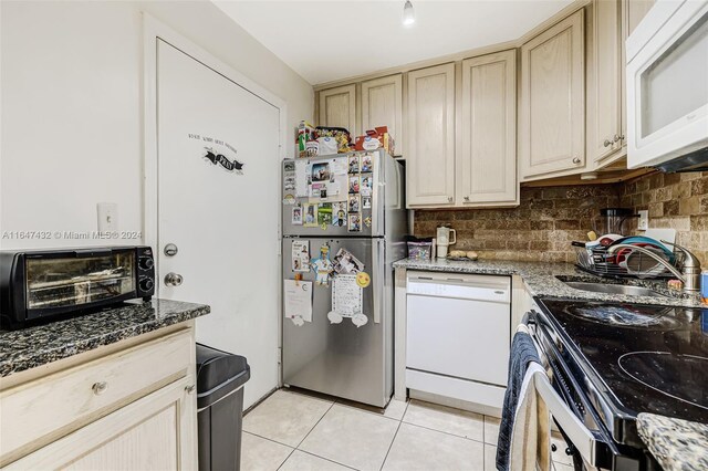 kitchen featuring appliances with stainless steel finishes, light brown cabinetry, light tile patterned floors, and tasteful backsplash