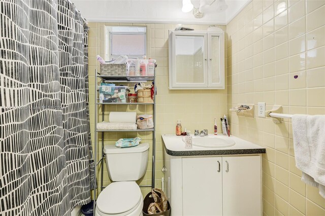 bathroom featuring tile walls, toilet, vanity, and walk in shower