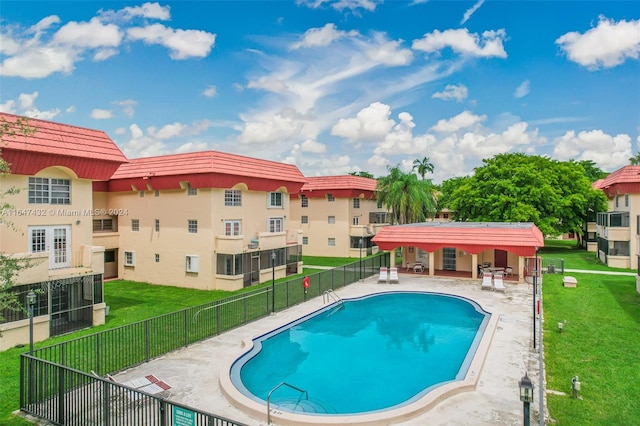 view of swimming pool with a patio area and a yard