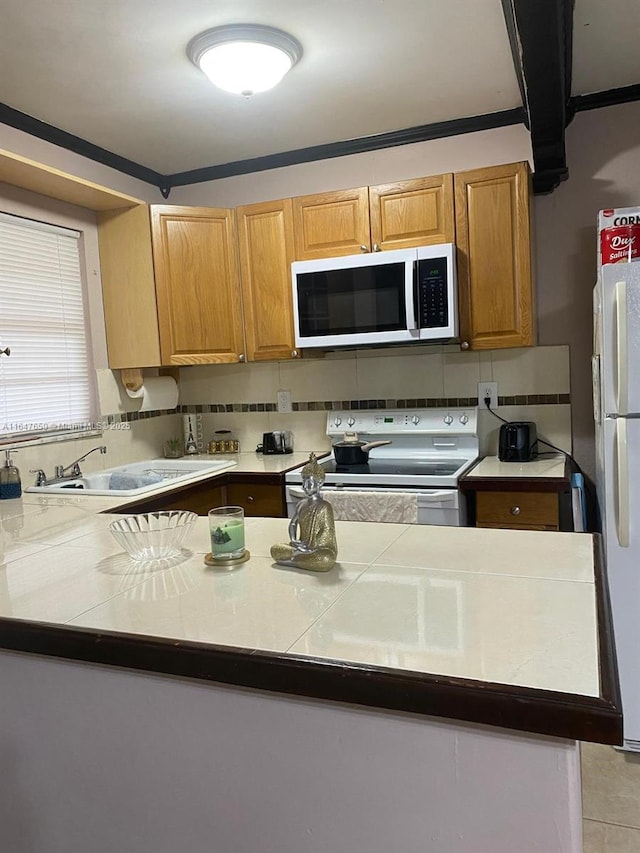 kitchen with tasteful backsplash, sink, and white appliances