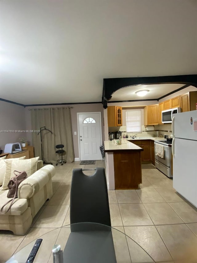 kitchen featuring white appliances, a kitchen bar, and light tile patterned floors