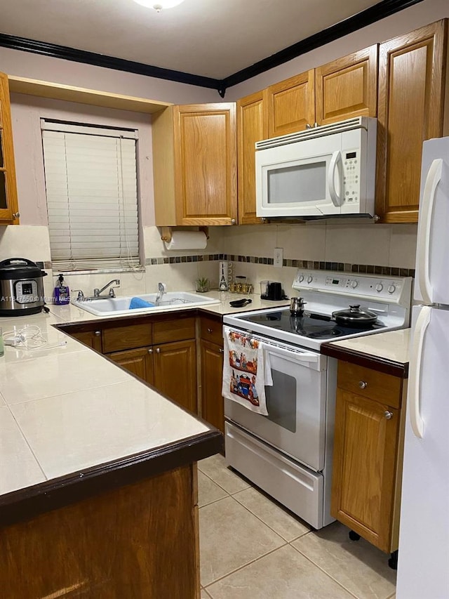 kitchen featuring light tile patterned floors, white appliances, sink, and backsplash