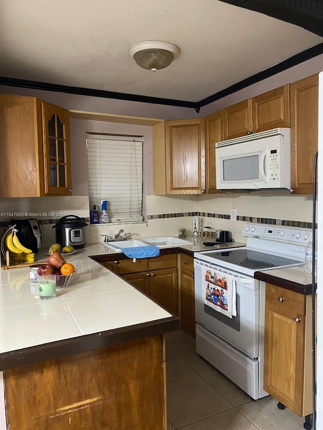 kitchen featuring tile patterned flooring, sink, white appliances, and tasteful backsplash