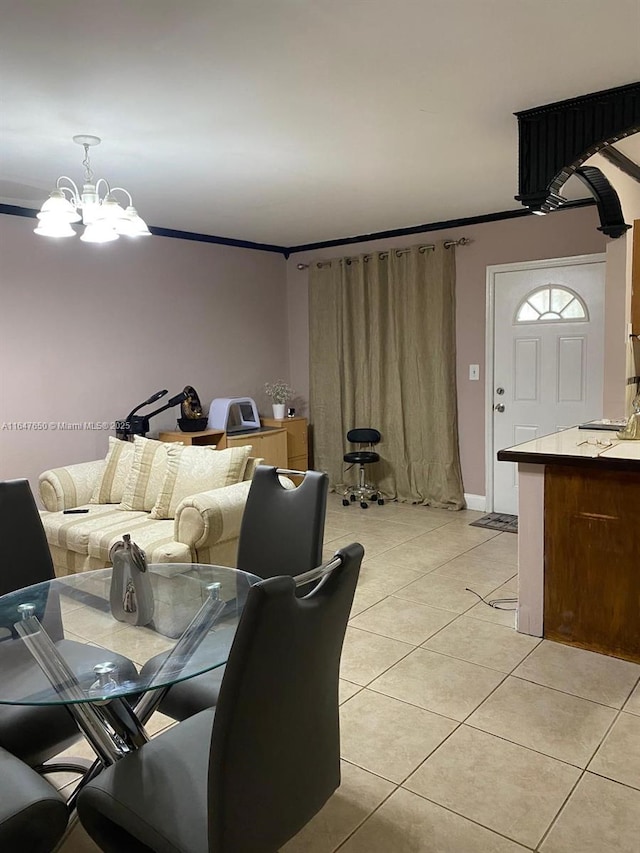 dining room with light tile patterned floors, ornamental molding, and a chandelier