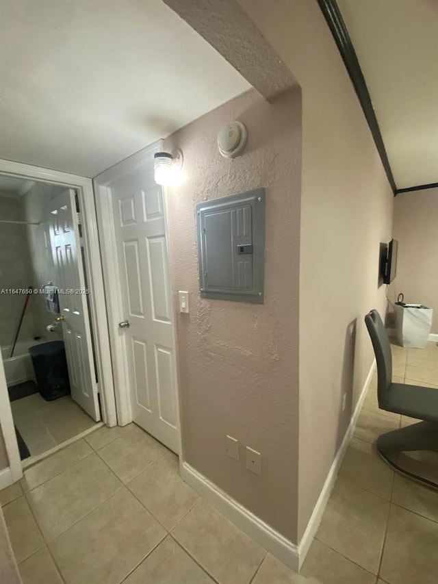 hallway featuring ornamental molding, light tile patterned floors, and electric panel