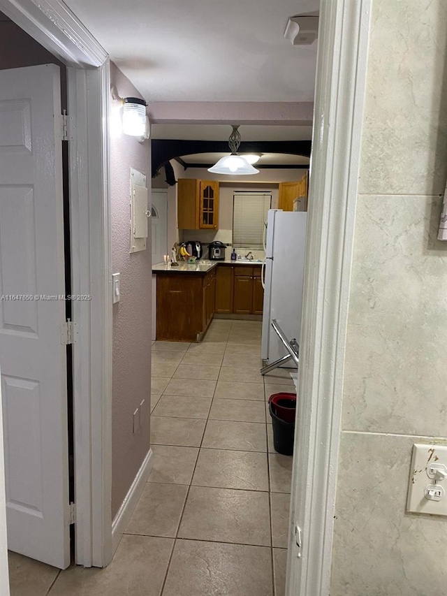 kitchen featuring light tile patterned flooring and white fridge