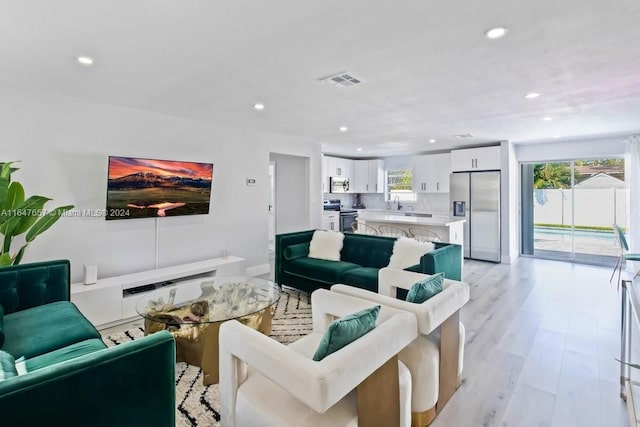 living room with light hardwood / wood-style flooring and sink