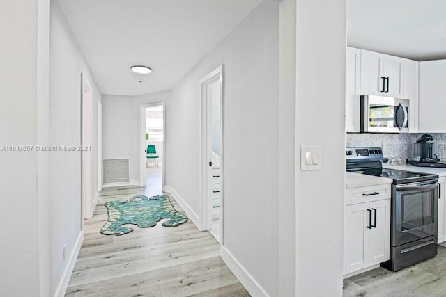 corridor with light hardwood / wood-style floors