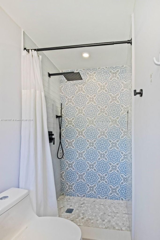 bathroom featuring a shower with shower curtain and toilet