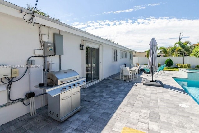 view of patio with a fenced in pool and a grill