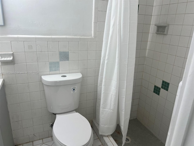 bathroom featuring toilet, walk in shower, tile patterned flooring, and tile walls