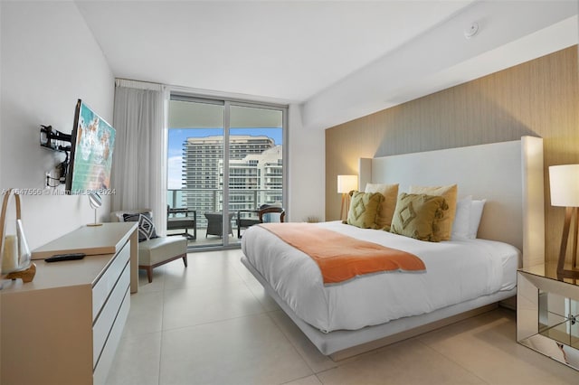 tiled bedroom featuring access to exterior and a wall of windows