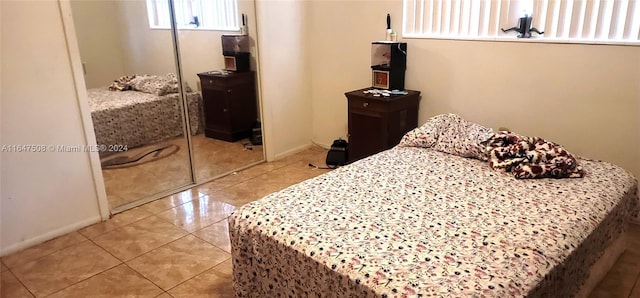 bedroom with a closet and light tile patterned flooring