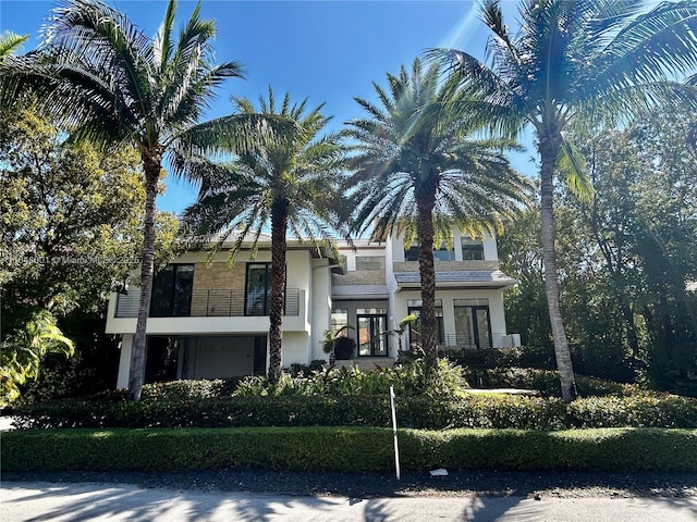 view of front facade featuring stucco siding and a balcony