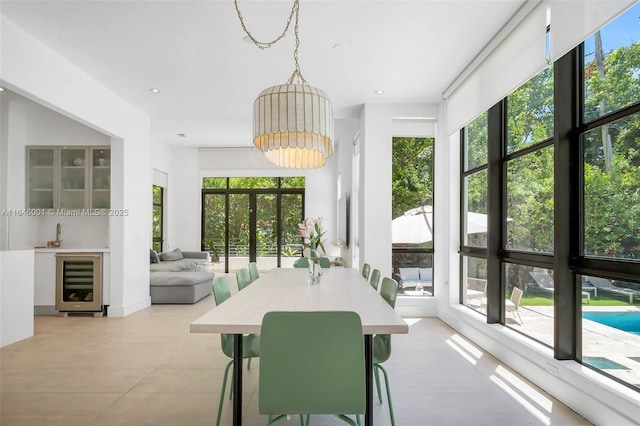 dining area with an inviting chandelier, recessed lighting, beverage cooler, and light tile patterned flooring