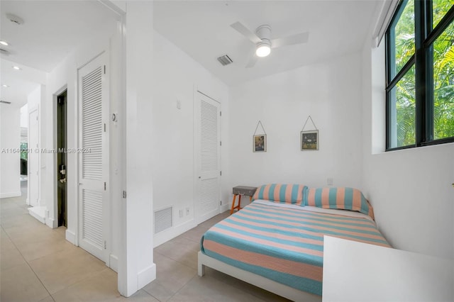 bedroom with ceiling fan and light tile patterned floors