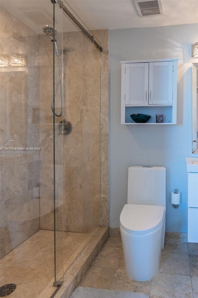 bathroom with a tile shower and toilet