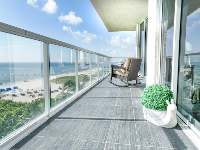 balcony featuring a water view and a view of the beach