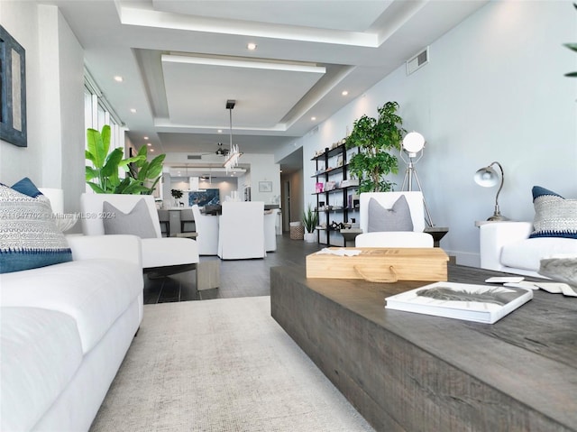 living room with a tray ceiling and dark hardwood / wood-style floors