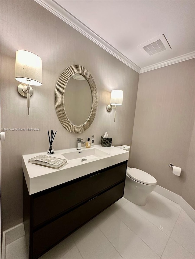 bathroom with toilet, crown molding, vanity, and tile patterned flooring