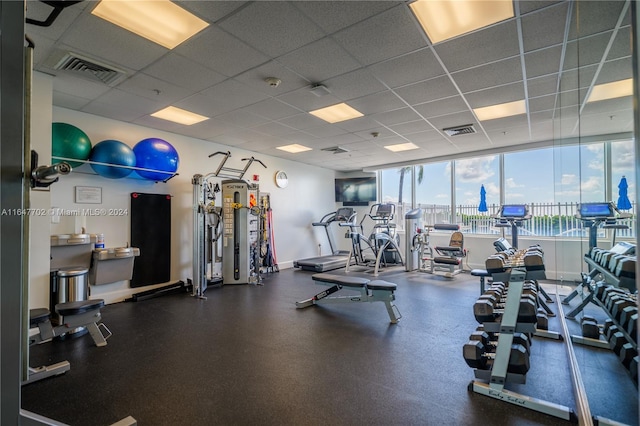 workout area with a drop ceiling and floor to ceiling windows