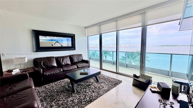 living room with light tile patterned flooring, a wall of windows, and a water view