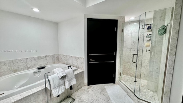 bathroom with tile patterned flooring and separate shower and tub