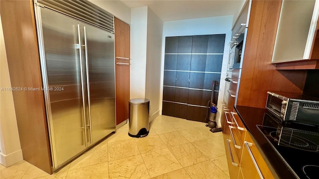 kitchen with stainless steel built in fridge and light tile patterned floors