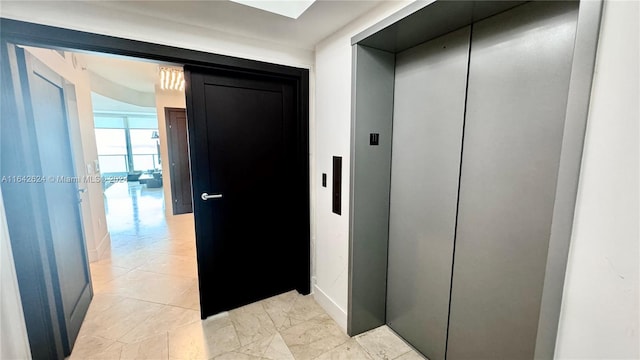 hall featuring elevator and light tile patterned floors