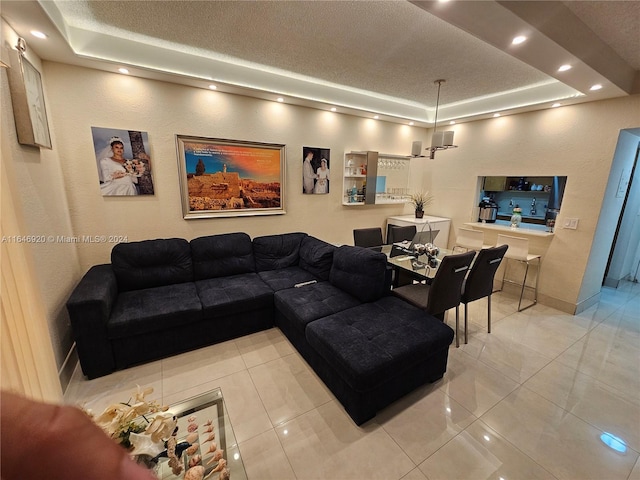 tiled living room with a textured ceiling and a tray ceiling