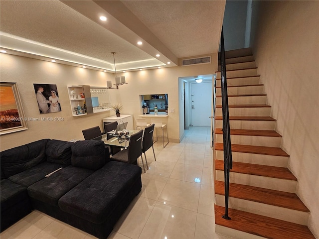 tiled living room with a textured ceiling and a tray ceiling