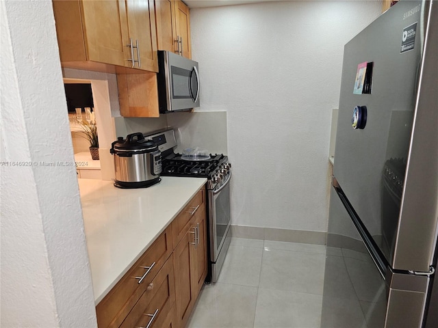 kitchen featuring appliances with stainless steel finishes and light tile patterned flooring