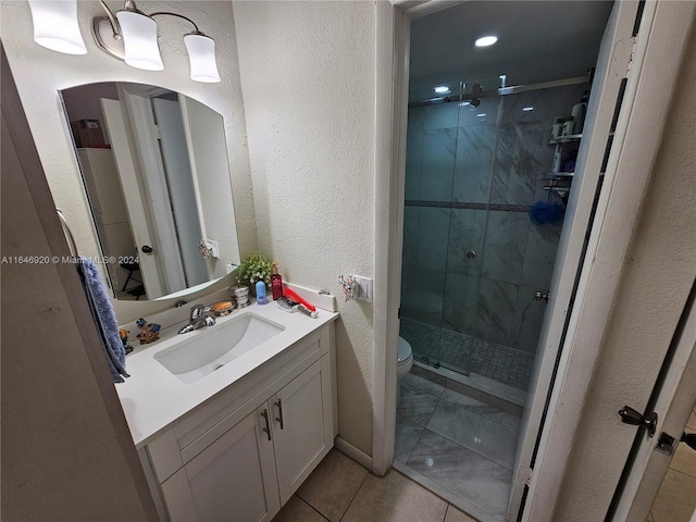 bathroom with tile patterned flooring, toilet, vanity, and a shower with shower door