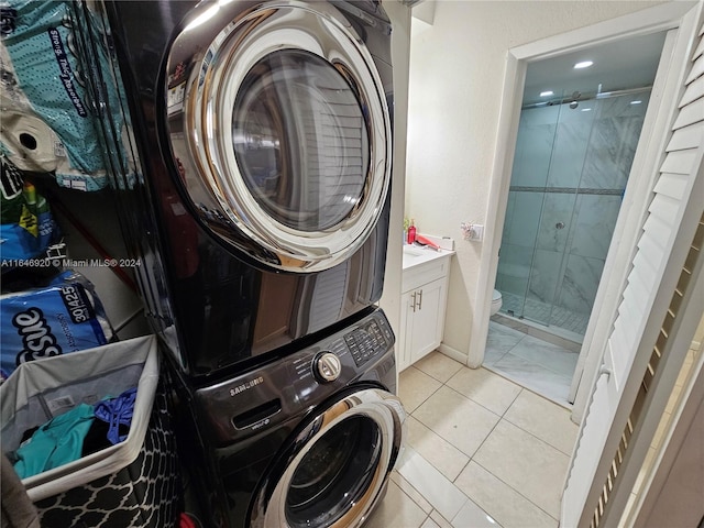 laundry room featuring light tile patterned flooring and stacked washer and clothes dryer