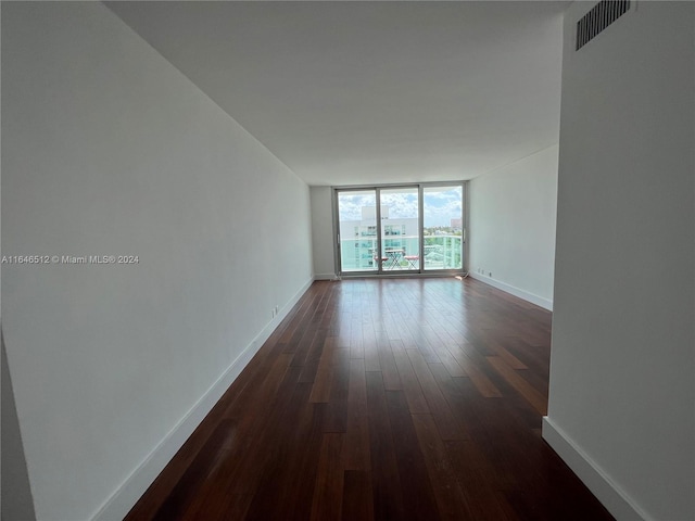 spare room with a wall of windows and hardwood / wood-style flooring