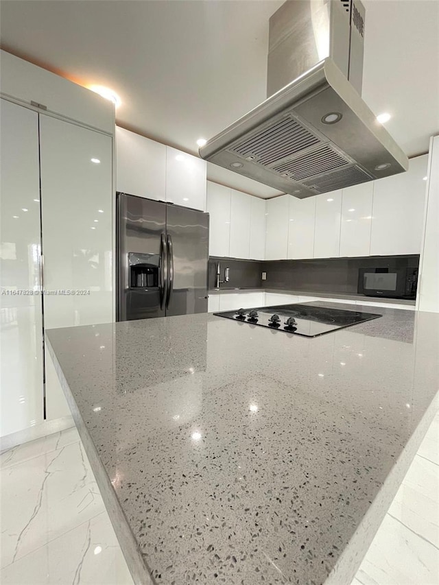 kitchen with white cabinetry, light stone countertops, stainless steel refrigerator with ice dispenser, black electric cooktop, and island range hood