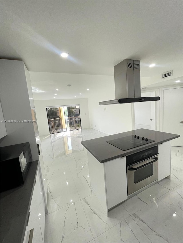 kitchen with black electric cooktop, white cabinetry, and stainless steel oven