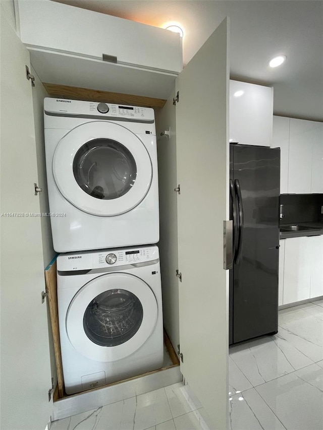 laundry room featuring stacked washer / drying machine