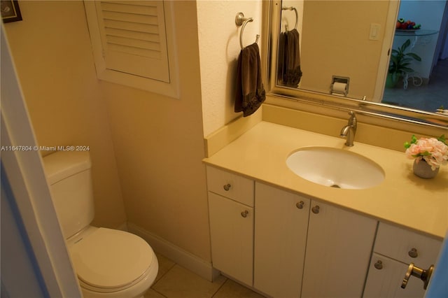 bathroom with tile patterned flooring, vanity, and toilet