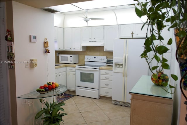 kitchen with light tile patterned floors, white appliances, tasteful backsplash, and white cabinetry