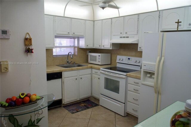 kitchen featuring white cabinetry, sink, light tile patterned floors, and white appliances