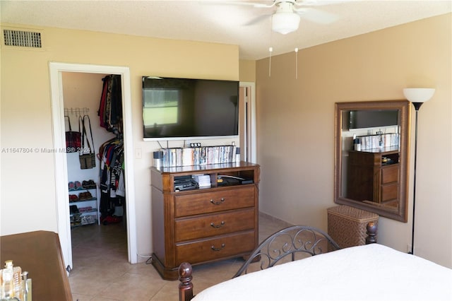 bedroom with ceiling fan, radiator heating unit, a textured ceiling, a closet, and light tile patterned floors