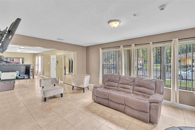 tiled living room featuring ceiling fan