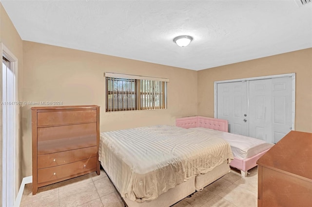 bedroom with a closet and light tile patterned flooring