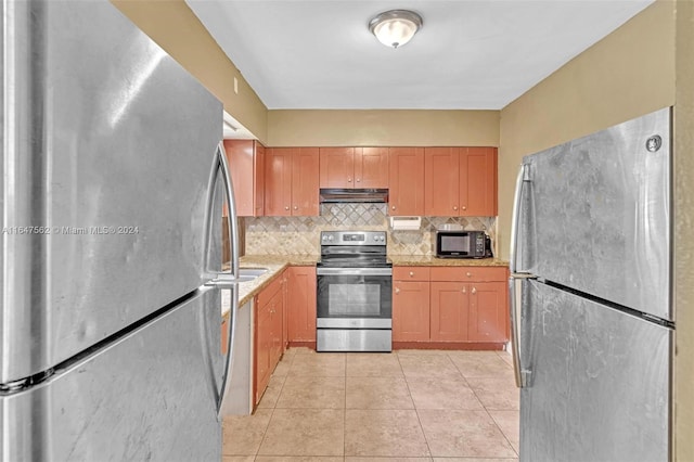 kitchen with light tile patterned floors, appliances with stainless steel finishes, and decorative backsplash