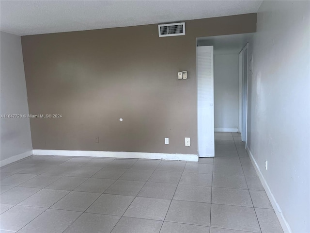 tiled spare room with a textured ceiling