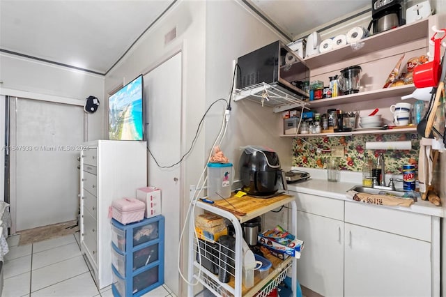 kitchen with sink, white cabinetry, and light tile patterned floors