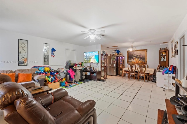 tiled living room with ceiling fan with notable chandelier